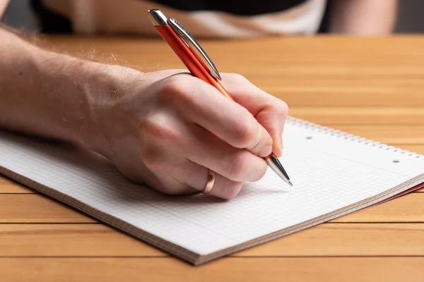 Mão masculina segurando uma caneta. Escrever no papel — Fotografia de Stock