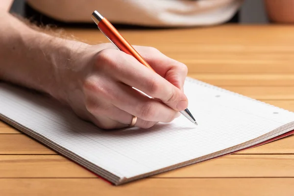 Αρσενικό χέρι που κρατάει στυλό. Γράφοντας στο χαρτί — Φωτογραφία Αρχείου