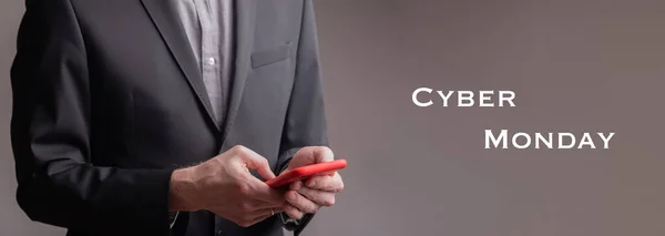 Bir iş adamı kırmızı cep telefonuyla yazı yazıyor - siber pazartesi.
