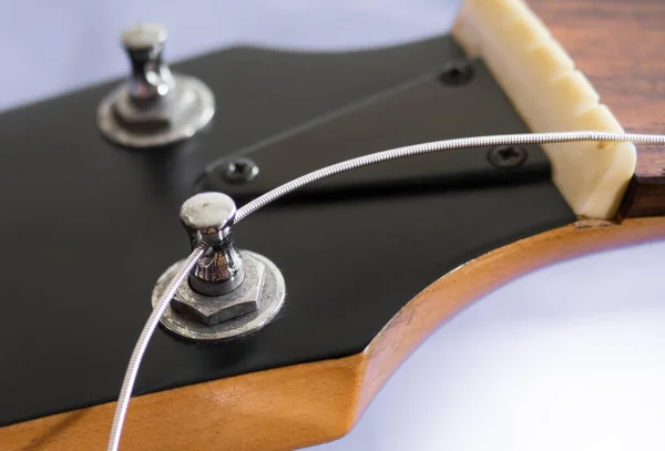 Gitar teli akort mandalı ve gitar teli düğme deliğine kuruluyor.
