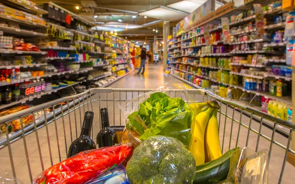 Carro de supermercado lleno de productos alimenticios saludables — Foto de Stock