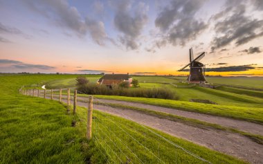 Hollandalı ahşap yel değirmeni daire çimenli peyzaj 