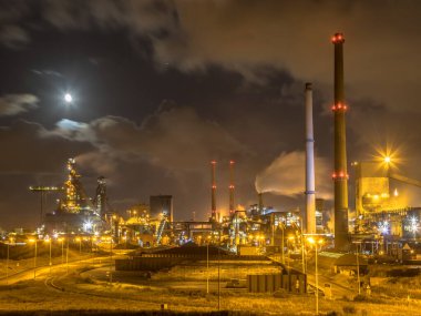 Gece dolunayda çelik fabrikası. Velsen Noord 'da ağır endüstri sahnesi. Hollanda 'da..