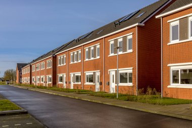 Hollanda 'daki bir köyde temel kamu konutlarında yepyeni bir gelişme. Modern banliyö teraslı evleri olan mahalle manzarası.