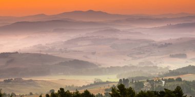 Tuscany tepecikli manzara. Sabahın erken saatlerinde köy kırsalında puslu bir hava.