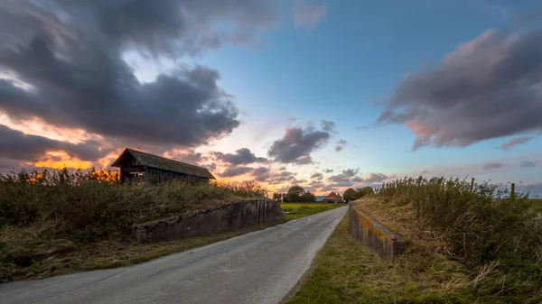Wegendoorgang Door Dijk Bij Zonsondergang Onder Prachtige Bewolkte Hemel Usquert — Stockfoto
