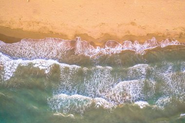 Korsika, Fransa 'nın altın renkli plajındaki deniz dalgalarının yukarıdan görünüşü.
