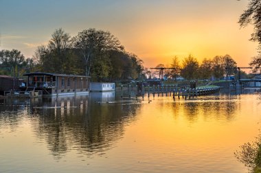 Sunset over houseboats and bridge in Willemsvaart canal in Zwolle, Overijssel province, the Netherlands.Landscape scene of nature in Europe. clipart