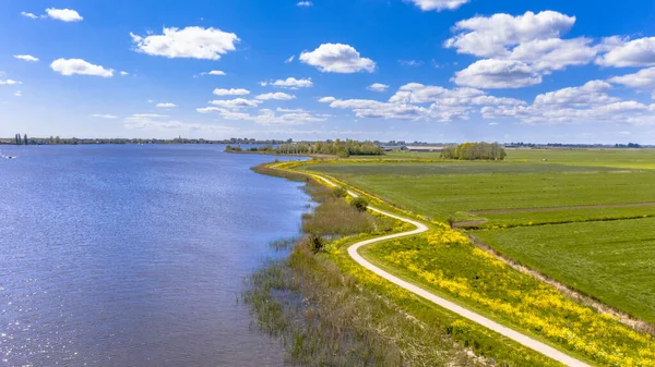 春天空中布恩茨瓦格附近的杜奇河场景 堤坝上的自行车道 带黄色花朵的弯弯曲曲的路基 荷兰弗里斯兰 — 图库照片