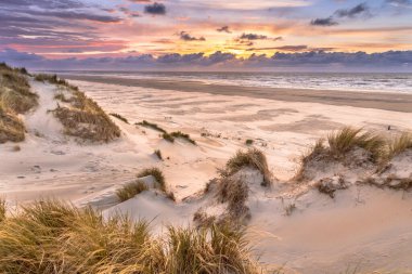 Hollanda 'nın Ameland adasından Kuzey Denizi üzerindeki kum tepesinden gün batımı görüntüsü