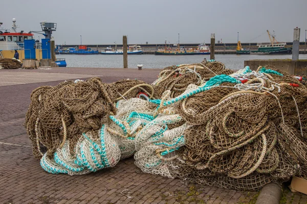 Stapel van visnetten op de kade van een vissershaven — Stockfoto