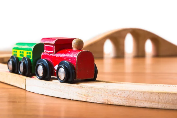 Leksakståg i trä med bron i bakgrunden — Stockfoto