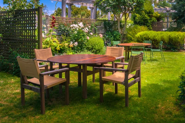 Esstisch im üppigen Garten gedeckt — Stockfoto