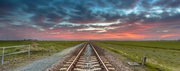 Oneindige spoorweg panorama in open platteland — Stockfoto
