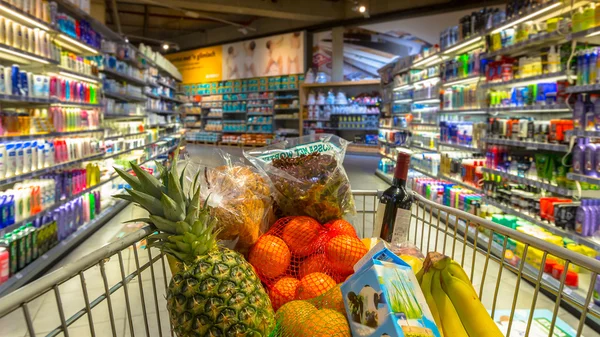 Carro en el supermercado con productos alimenticios —  Fotos de Stock