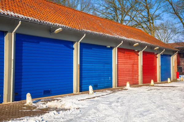 Garage Doors in in blue and red next to each other on a Snowy Wi — 图库照片