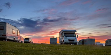 Caravans and cars campsite sunset clipart