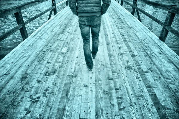 Men walking on wooden bridge