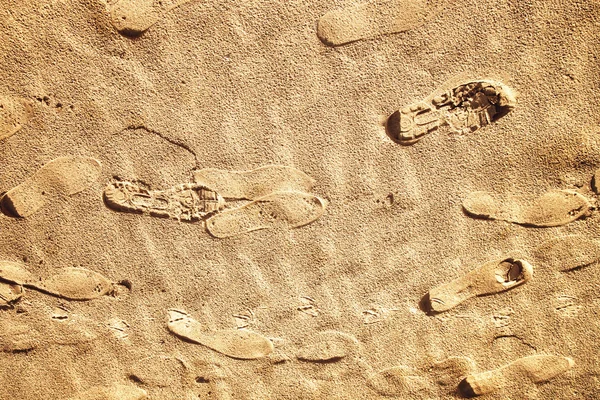 Imprint of the shoes on sunny beach sand