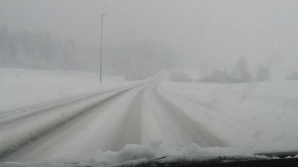 Carro em câmera lenta dirigindo em queda de neve pesada — Vídeo de Stock