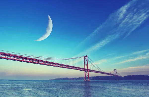 Neumond über roter Brücke bei Sonnenuntergang, Lissabon, Portugal — Stockfoto