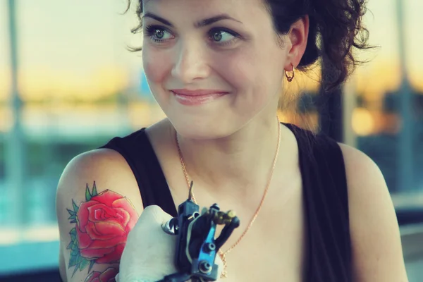 Татуювання, що показує процес створення татуювання на молодій красивій жінці-хіппері з червоним кучерявим волоссям — стокове фото