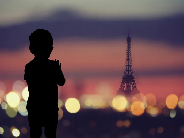 Silueta de un niño en la ventana con silueta de la torre Eiffel — Foto de Stock