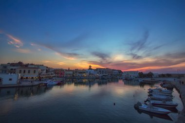 Yunanistan 'ın Girit kentindeki deniz feneri ve eski liman manzarası, Akdeniz' de güzel bir gün batımında. Aşk ve seyahat geçmişi
