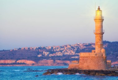 Yunanistan 'ın Girit kentindeki deniz feneri ve eski liman manzarası, Akdeniz' de güzel bir gün batımında. Aşk ve seyahat geçmişi