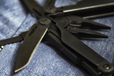 Genişletilmiş araç ve kerpetenle kot arka planına yakın siyah çoklu araç (çoklu araç). İş ve zanaat kavramı.