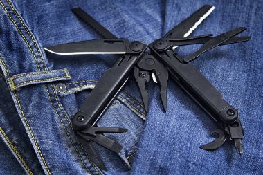 Genişletilmiş araç ve kerpetenle kot arka planına yakın siyah çoklu araç (çoklu araç). İş ve zanaat kavramı.