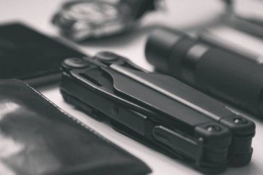 Beyaz arka planda siyah renkli erkekler için günlük eşyalar - el feneri, saat, çok amaçlı çoklu araç, telefon, kalem. Modern şehir seti. Asgari konsept.