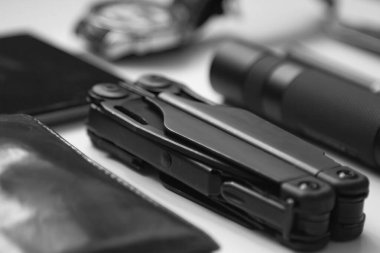 Beyaz arka planda siyah renkli erkekler için günlük eşyalar - el feneri, saat, çok amaçlı çoklu araç, telefon, kalem. Modern şehir seti. Minimum konsept. Modern şehir.