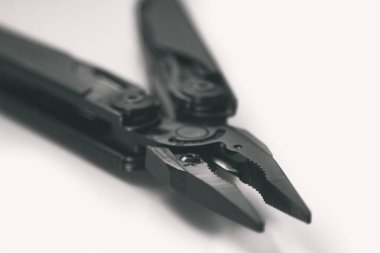 çok araçlı siyah pense (çok araçlı) küçük alan derinliği ile beyaz arka planda kapalı. İş ve zanaat kavramı