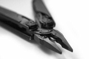 çok araçlı siyah pense (çok araçlı) küçük alan derinliği ile beyaz arka planda kapalı. İş ve zanaat kavramı