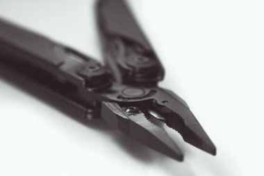 çok araçlı siyah pense (çok araçlı) küçük alan derinliği ile sarı arka planda kapalı. İş ve zanaat kavramı