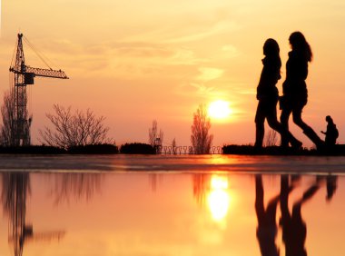 Sunset bulvarında bir arka plan ile iki arkadaş silüeti. Genç kadın birkaç gün batımı sırasında - genç kızlar açık havada birlikte eğleniyor yürüyüş arkadaşlarım