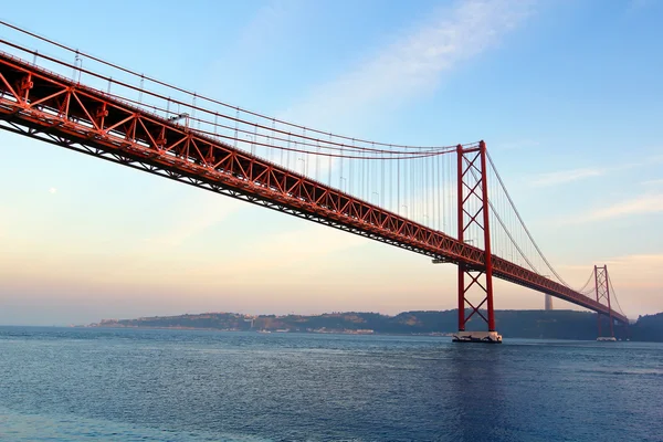 Rote Brücke bei Sonnenuntergang (Brücke 25 de abril und Statue Cristo rei), Lissabon, Portugal — Stockfoto