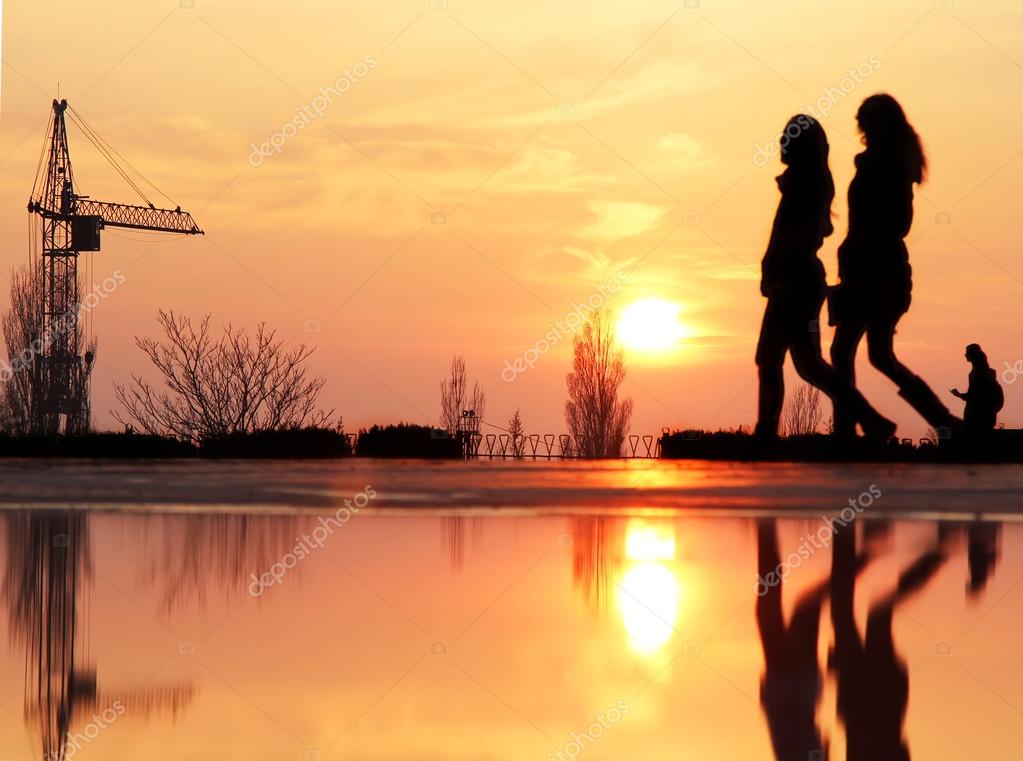 two friends walking in the sunset