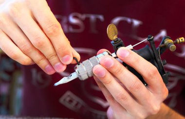 Bir dövme yapma işlemi gösteren tattooer. Dört yapraklı yonca şeklinde tasarım dövme