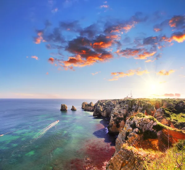 Praia rochosa ao pôr do sol, Lagos, Portugal. Contra-luz. Viagens e negócios — Fotografia de Stock