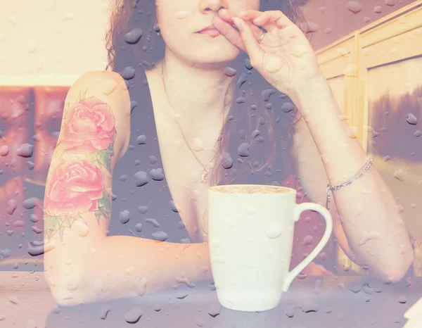 Exposição dupla: jovem mulher bonita hipster tatuado com cabelo encaracolado vermelho no bar com xícara de café. Imagem estilo vintage Fotografia De Stock