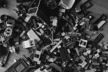 Lego siyah beyaz arka planda. Bir sürü oyuncak tuğla arka planı var. Çocuklar için eğitici bir oyuncak.