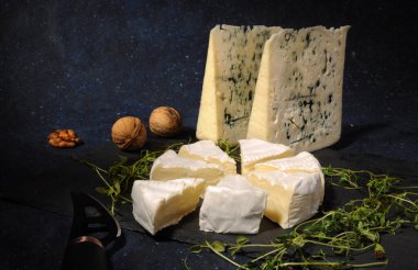 Taş bir tahtanın üzerinde, fındıklı ve bıçaklı mavi peynir..