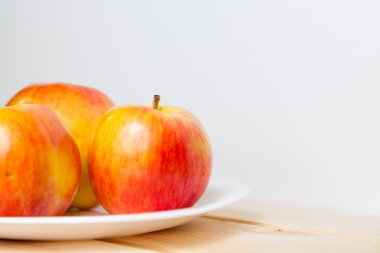 ahşap bir masa üzerinde bir kabın içinde elma