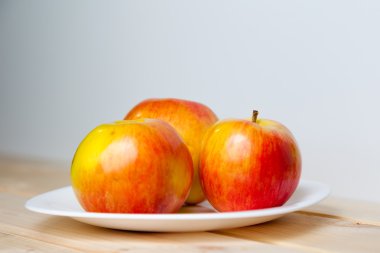 ahşap bir masa üzerinde bir kabın içinde elma