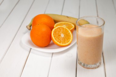 Ahşap masa üzerinde sağlıklı içecek portakal ve muz smoothies