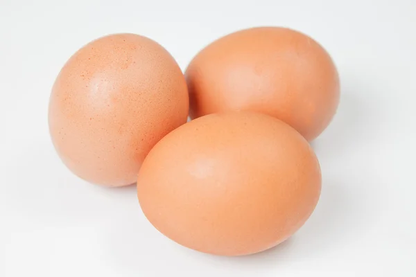 Три куриных яйца на белом фоне — стоковое фото