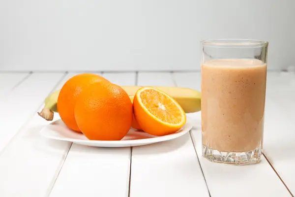 Healthy drink orange and banana smoothies on wooden table — Stock Photo, Image