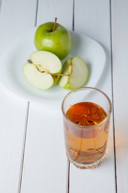 Yeşil elma ve bir ahşap zemin üzerine suyu